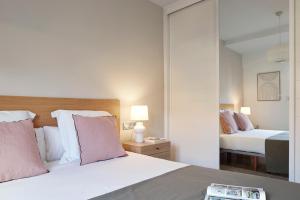 1 dormitorio con 2 camas y espejo en Mirakruz Terrace by FeelFree Rentals, en San Sebastián