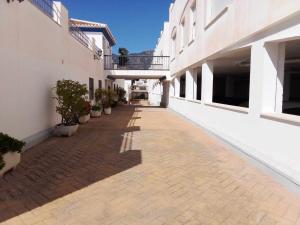 an empty alley between two buildings with potted plants at Fantástico estudio en Urbanización Vela de Mar in Benalmádena +37 photos