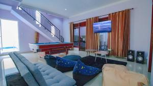 a living room with a couch and a pool table at Villa Surga Dunia with Private Pool and Billiard in Batu