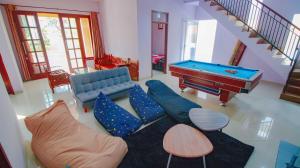 a living room with a couch and a pool table at Villa Surga Dunia with Private Pool and Billiard in Batu