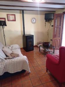 - un salon avec un canapé et une cuisinière dans l'établissement CASA RURAL SAN JULIAN, à Villahermosa del Río