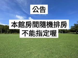 un cartel con escritura china en un campo de hierba en My Chateau Resort, en Kenting