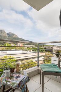 a balcony with a table and a view of mountains at The Rondebosch on Belmont in Cape Town
