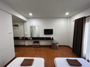 a living room with two beds and a mirror at Bordin Hotel in Ubon Ratchathani
