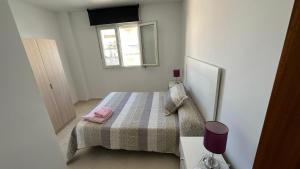 Un dormitorio pequeño con una cama y una ventana. en APARTAMENTO el CARMEN, en Baeza