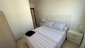 Un dormitorio pequeño con una cama con una manta de rayas. en APARTAMENTO el CARMEN, en Baeza 2 fotos más