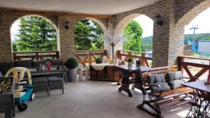 een patio met een bank, tafels en stoelen bij Nartorama HotRest in Zieleniec