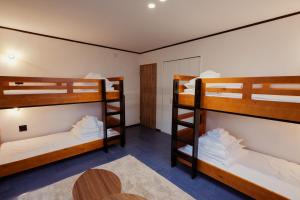 two bunk beds in a room with a table at Bridge33 CAFE AND HOSTEL in Takagi