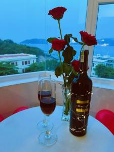 a bottle of wine and a glass of red roses at CLIFF HOUSE managed by DHG in Nha Trang