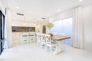 a kitchen and dining room with a wooden table and chairs at East Vic Park Glamour- EXECUTIVE ESCAPES in Perth
