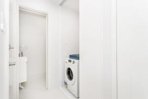- une buanderie blanche avec lave-linge et sèche-linge dans l'établissement East Vic Park Glamour- EXECUTIVE ESCAPES, à Perth