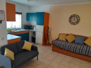 a living room with a couch and a kitchen at Residence 1000 Roses in Moncarapacho