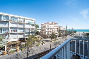 - un balcon avec vue sur la plage et les bâtiments dans l'établissement Les Arcades - Appartement vue mer, à Argelès-sur-Mer