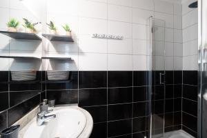 czarno-biała łazienka z umywalką i prysznicem w obiekcie Les Arcades - Appartement vue mer w Argelès-sur-Mer +5 zdjęć