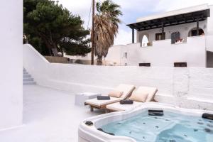 Sunrise Villa Santorini في Vourvoúlos: حوض استحمام ساخن على فناء المنزل