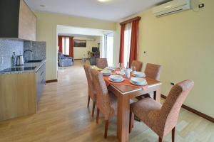 布德瓦的住宿－Dolce Vita，厨房以及带木桌和椅子的用餐室。