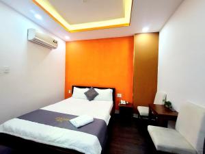 een hotelkamer met een bed, een bureau en een stoel bij Nam Anh 2 Hotel in Ho Chi Minh-stad