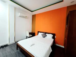 een slaapkamer met een bed met een oranje muur bij Nam Anh 2 Hotel in Ho Chi Minh-stad