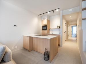 a kitchen with a island in the middle of a room at -Hannah- stijlvol,nieuw vakantieverblijf De Panne in De Panne