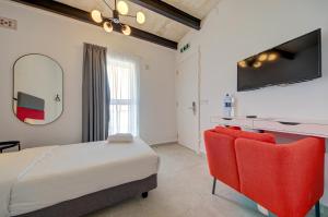 a bedroom with a bed and two red chairs at Casa Domenico 8 in Valletta