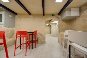 瓦萊塔的住宿－Casa Domenico 8，一间用餐室,配有红色的椅子和桌子