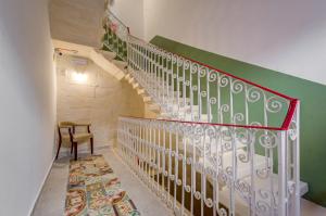 a staircase with a green and white railing and a chair at Casa Domenico 8 in Valletta