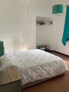 Un dormitorio con una gran cama blanca y una mesa en Terre dei Principi Bassiano, en Bassiano