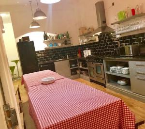 a kitchen with a table with a red and white checkered table cloth at The Valleys House Cardiff Bay in Cardiff