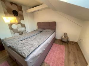 a bedroom with a large bed with a pink rug at Apartman 4YOU Central station - GARAGE - Self check in in Osijek