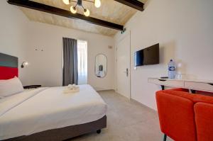 a bedroom with a large bed and a tv at Casa Domenico 6 in Valletta