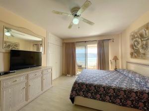 a bedroom with a bed and a flat screen tv at Edificio Arco in Los Cristianos