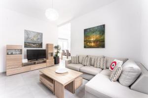 un soggiorno con divano e TV di Sunrise Villa Santorini a Vourvoúlos
