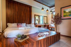 - une chambre avec un grand lit et une tête de lit en bois dans l'établissement Bentong Eco Wellness Resort 14Room 69Pax by Verano Homestay, à Bentong