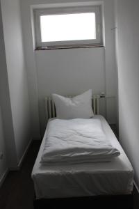 Cama blanca en habitación con ventana en Rasthaus Hotel Schackendorf, en Schackendorf