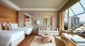 a hotel room with two beds and a desk at The Ritz-Carlton, Millenia Singapore in Singapore