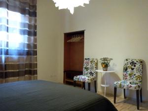 una camera da letto con due sedie, un letto e un tavolo di Ai Gabbiani a Verona