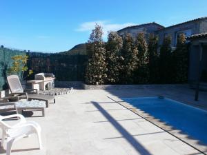 a patio with chairs and a swimming pool at Le Domaine De Marie in Palasca