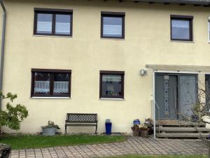 a yellow house with a bench in front of it at Ferienwohnung SCHWARZACHHÖHE nur für Erwachsene in Wendelstein