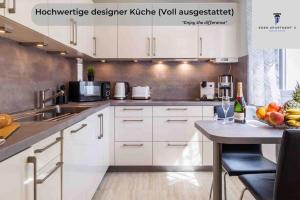 una cucina con armadi bianchi e un tavolo con frutta di Ferienwohnung EDEN Apartment´s Vinum a Friedrichshafen