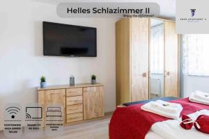 una camera con TV a parete e un letto di Ferienwohnung EDEN Apartment´s Vinum a Friedrichshafen