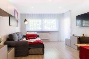 un soggiorno con divano e coperta rossa di Ferienwohnung EDEN Apartment´s Vinum a Friedrichshafen
