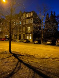 uma sombra de uma árvore em frente a um edifício em Studio confort Verviers em Verviers