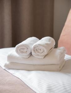 2 handdoeken worden op een bed gestapeld bij Dobra Old Town Apartment in Warschau
