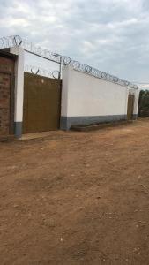 a building with a fence and a gate at Chez Catherine et Gabriel in Bangui