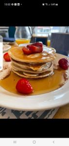 a stack of pancakes with strawberries on a plate at Merritt Guest House B&B in Paignton