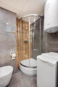 een badkamer met een douche en een toilet bij Dobra Old Town Apartment in Warschau