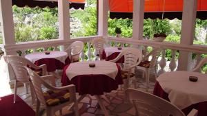 a restaurant with white tables and chairs with red and white table cloth at PENSION SEA QUEEN JADRANKA DIREKT am MEHR in Omišalj