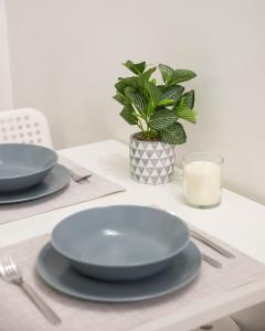 a table with plates and a plant and a glass of milk at Dobra Old Town Apartment in Warsaw