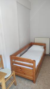 ein Holzbett in einem Zimmer mit einem Tisch und einem Stuhl in der Unterkunft Nikos Apartments A6 in Gialiskari