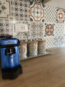 a coffee maker on a shelf in front of a wall with tiles at Anema & Core Home in Porto SantʼElpidio
